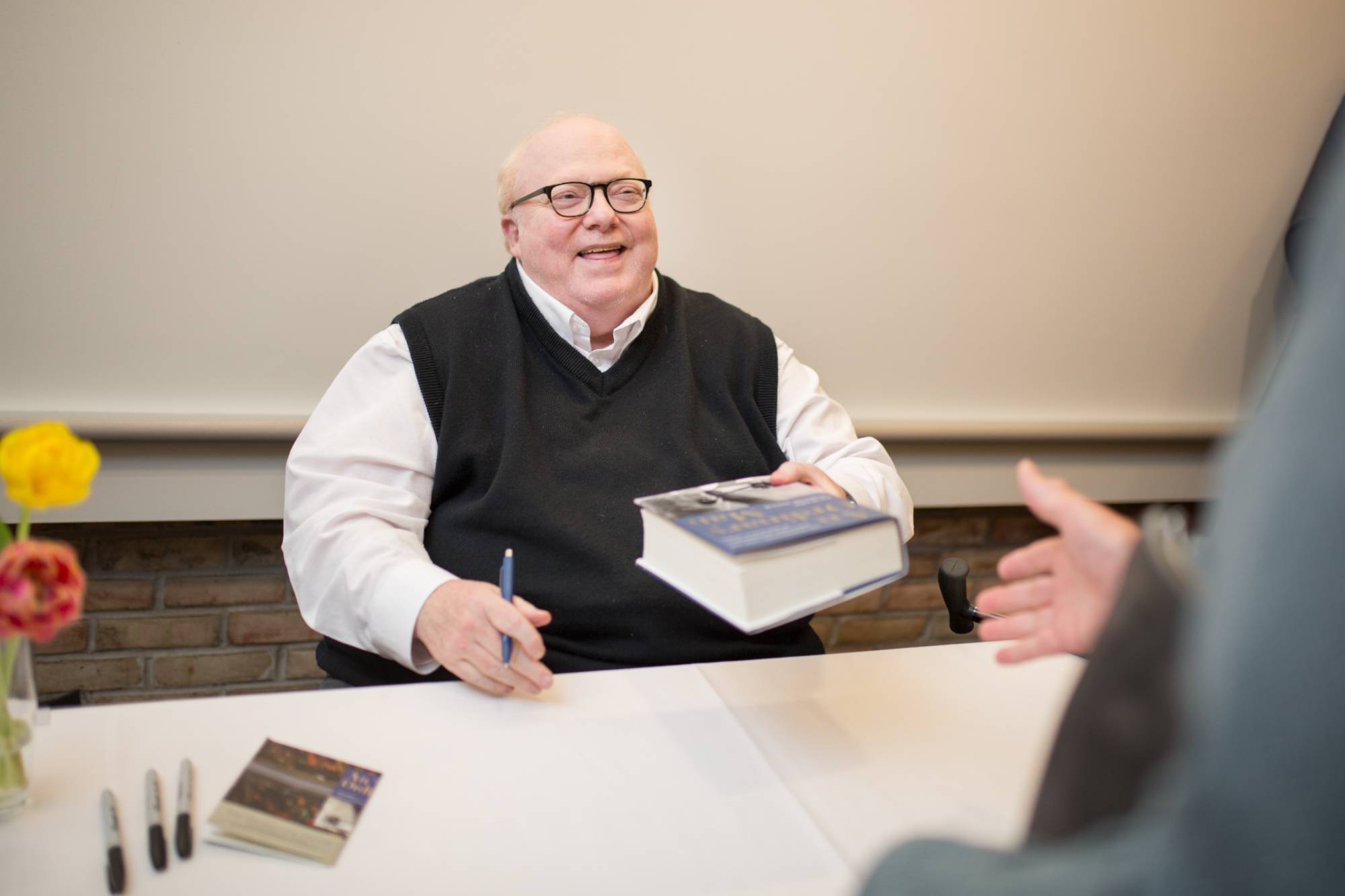 Man giving book with a smile